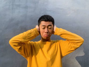 Neşeli bir Güneydoğu Asyalı adam, komik bir ifadeyle, kahkaha ve mutluluğun ruh sağlığı için güçlü bir ilaç, komik bir yüz olduğu fikrini somutlaştırıyor.