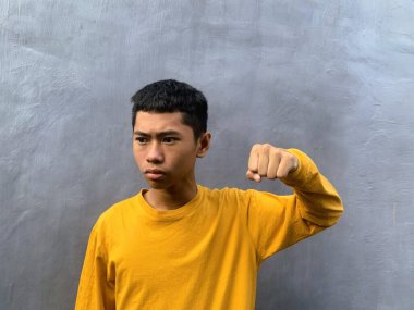 Saldırıya hazır genç bir adam tehditkar bir şiddet eylemini ve zorbalık tehdidini yakalıyor.