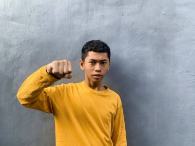 Saldırıya hazır genç bir adam tehditkar bir şiddet eylemini ve zorbalık tehdidini yakalıyor.