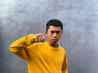 Saldırıya hazır genç bir adam tehditkar bir şiddet eylemini ve zorbalık tehdidini yakalıyor.