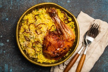 Lezzetli Hint yemeği Biryani tavuk budu ve pirinçli basmati pilavı masa taşından kırsal arka planda eski bir kase. Hindistan 'ın geleneksel vejetaryen olmayan yemekleri.