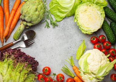 Taze organik sebzeler, kaşık, kırsal gri masa üzerindeki çatal üst görünüm fotokopi alanı. Vejetaryen gıda geçmişi ve vitamin konsepti, diyet ve temiz yemek içeren sağlıklı sebze malzemeleri.