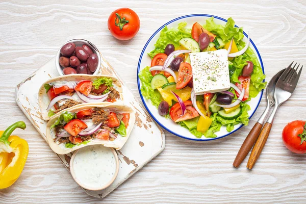 伝統的なギリシャ料理 ギリシャのサラダ 肉や野菜とジャイロ Tzatzikiソース 白い素朴な木製のテーブルの背景の上からの眺めにオリーブ ギリシャ料理 — ストック写真