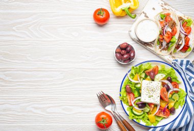 Geleneksel Yunan Gıda: Yunan Salatası, et ve sebzeli jiroskoplar, Tzatziki sosu, yukarıdan gelen beyaz rustik ahşap masa zemininde zeytinler. Yunanistan mutfağı. Boşluğu kopyala