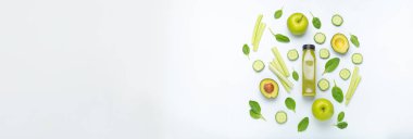 Yeşil meyve ve sebzelerle çevrili bir şişe yeşil smoothie: beyaz arka planda elma, avokado, ıspanak, kereviz, salatalık. Diyet, sağlıklı beslenme, detoks, kopyalama alanı