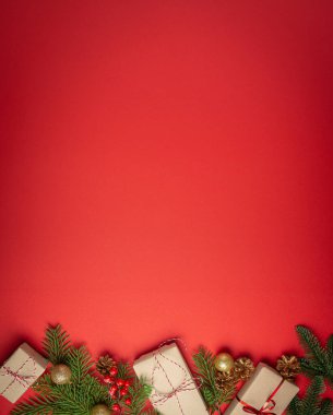 Noel ya da Yeni Yıl kutlamaları kırmızı kağıt şenliği arka planında süsleme köknar ağacı, hediye kutuları, koniler, böğürtlenler, parlak kırmızı toplar. Metin için boşluk..