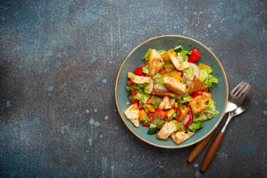Geleneksel Levant yemeği Fatoush salatası, Arap mutfağı, Pita ekmekli kızarmış ekmek, sebzeler, bitkiler. Sağlıklı Orta Doğulu vejetaryen salatası tabakta, koyu mavi arka plan manzarası, kopyalama alanı.