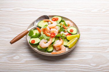 Beyaz masada taze malzemeli lezzetli karides salatası. Yazın sağlıklı yemekler için mükemmel. Sebze salatalı karidesin yukarıdan görünüşü, aşçılık becerilerini sergilemek için ideal.