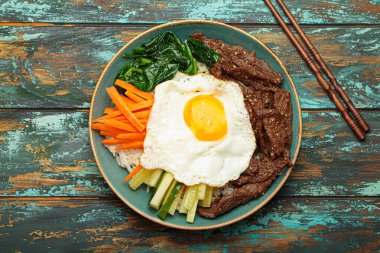 Bir tabak bibimbap, karışık pirinç yemeği et ve çeşitli sebzeler, geleneksel Kore mutfağı. Yemek gochujang ile tatlandırılır - chili biber ezmesi - ve üzeri kızarmış yumurta ile kaplıdır.
