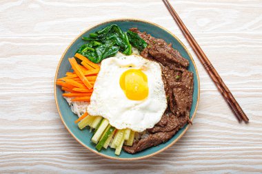 Bir tabak bibimbap, karışık pirinç yemeği et ve çeşitli sebzeler, geleneksel Kore mutfağı. Yemek gochujang ile tatlandırılır - chili biber ezmesi - ve üzeri kızarmış yumurta ile kaplıdır.