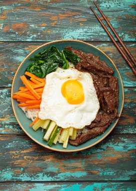 Bir tabak bibimbap, karışık pirinç yemeği et ve çeşitli sebzeler, geleneksel Kore mutfağı. Yemek gochujang ile tatlandırılır - chili biber ezmesi - ve üzeri kızarmış yumurta ile kaplıdır.