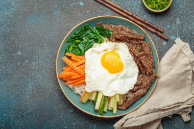 Bir tabak bibimbap, karışık pirinç yemeği et ve çeşitli sebzeler, geleneksel Kore mutfağı. Yemek gochujang ile tatlandırılır - chili biber ezmesi - ve üzeri kızarmış yumurta ile kaplıdır.