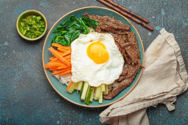 Bir tabak bibimbap, karışık pirinç yemeği et ve çeşitli sebzeler, geleneksel Kore mutfağı. Yemek gochujang ile tatlandırılır - chili biber ezmesi - ve üzeri kızarmış yumurta ile kaplıdır.