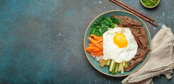 Bir tabak bibimbap, karışık pirinç yemeği et ve çeşitli sebzeler, geleneksel Kore mutfağı. Yemek gochujang ile tatlandırılır - chili biber ezmesi - ve üzeri kızarmış yumurta ile kaplıdır.