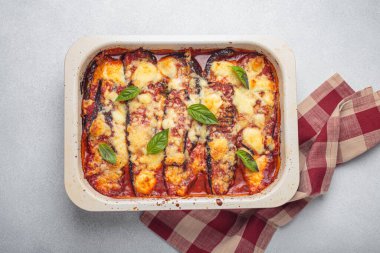 Parmesanlı patlıcan di melanzane taze pişmiş ve fesleğen yapraklarıyla süslenmiş, tavada dinleniyor. Klasik İtalyan yemeği.