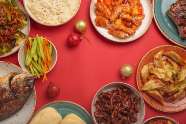 Şenlikli kırmızı arka planda geleneksel Çin yemekleri: kung pal tavuğu, tatlı ve ekşi domuz eti, erişte, mantı, mapo tofu, balık, pirinç, fal kurabiyeleri. Boşluğu kopyala