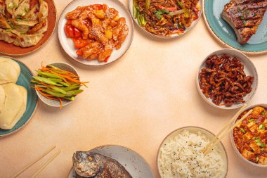 Tabaklardaki lezzetli Çin yemekleri ve tabaklar: kung pal tavuğu, tatlı ve ekşi domuz eti, erişte, hamur tatlısı, mapo tofu, balık, pirinç üst görünümü ve fotokopi alanı.