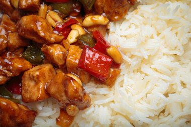 Çin kung pao tavuğunu pilav, sebze ve baharatlı soslu fıstık ile yakın çekim yapın. Koyu arkaplanda üst görünüm. Öğle veya akşam yemeği için mükemmel.