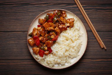 Çin usulü kung pao tavuğu pilav, sebze ve baharatlı soslu fıstık. Ahşap arka planda üst manzara. Öğle veya akşam yemeği için mükemmel.