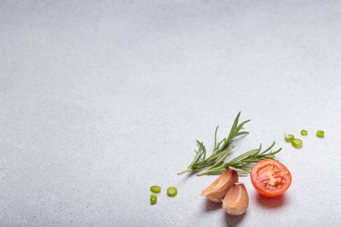 Taze kesilmiş sebzeler ve otlar gri arka planda boş bir alanı, sağlıklı ve organik bir yaşam tarzını, yemek pişirme konseptini çerçeveliyorlar.