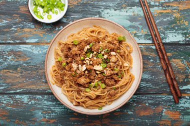 Dan Dan eriştesi fıstıklı ve yeşil soğanlı. Çubuklu. Sichuan mutfağında servis ediliyor.