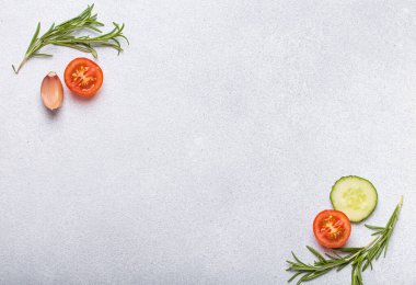 Taze kesilmiş sebzeler ve otlar gri arka planda boş bir alanı, sağlıklı ve organik bir yaşam tarzını, yemek pişirme konseptini çerçeveliyorlar.