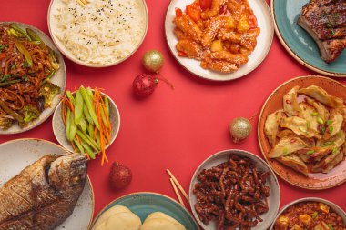 Şenlikli kırmızı arka planda geleneksel Çin yemekleri: kung pal tavuğu, tatlı ve ekşi domuz eti, erişte, mantı, mapo tofu, balık, pirinç, fal kurabiyeleri. Boşluğu kopyala