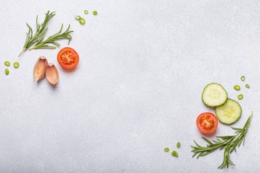 Taze kesilmiş sebzeler ve otlar gri arka planda boş bir alanı, sağlıklı ve organik bir yaşam tarzını, yemek pişirme konseptini çerçeveliyorlar.