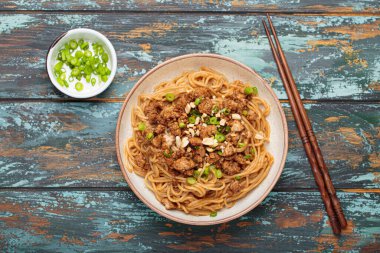 Dan Dan eriştesi fıstıklı ve yeşil soğanlı. Çubuklu. Sichuan mutfağında servis ediliyor.