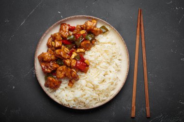 Çin usulü kung pao tavuğu pilav, sebze ve baharatlı soslu fıstık. Koyu arkaplanda üst görünüm. Öğle veya akşam yemeği için mükemmel.