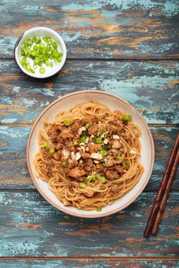 Dan Dan eriştesi fıstıklı ve yeşil soğanlı. Çubuklu. Sichuan mutfağında servis ediliyor.