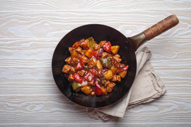 Renkli çan biberleri ve ananas parçalarıyla tavada tatlı ve ekşi domuz eti, klasik Asya yemeği.