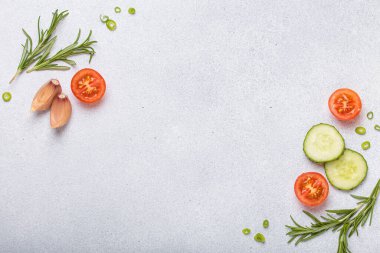 Taze kesilmiş sebzeler ve otlar gri arka planda boş bir alanı, sağlıklı ve organik bir yaşam tarzını, yemek pişirme konseptini çerçeveliyorlar.