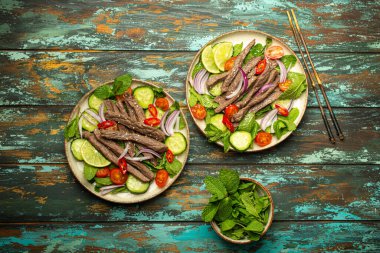 Geleneksel Tayland sığır eti salatası ve sebzeli ve nane soslu, ahşap arka planda servis edilen sağlıklı egzotik Asya yemeği..