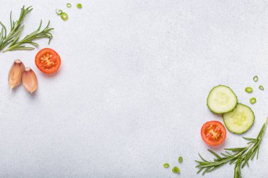 Taze kesilmiş sebzeler ve otlar gri arka planda boş bir alanı, sağlıklı ve organik bir yaşam tarzını, yemek pişirme konseptini çerçeveliyorlar.