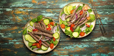 Geleneksel Tayland sığır eti salatası ve sebzeli ve nane soslu, ahşap arka planda servis edilen sağlıklı egzotik Asya yemeği..