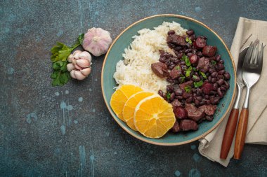 Beyaz pirinç ve portakal dilimleriyle dolu sağlıklı bir Brezilya güveci olan Feijoada, sarımsak ve maydanozla birlikte Brezilya 'nın canlı bir mutfak geleneğini sergiliyor.