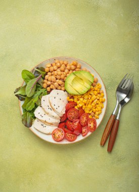 Kızarmış tavuk göğsü, nohut, avokado, mısır ve domatesli sağlıklı bir kase, dengeli ve besleyici bir yemek ve sağlıklı bir yaşam tarzı.