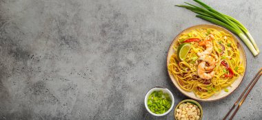 Karides, fıstık, soğan, kireç ve kırmızı dolma biber dilimli Tayland eriştesi seramik tabakta servis edilir. Tayland Tabağı, kopyalama alanı