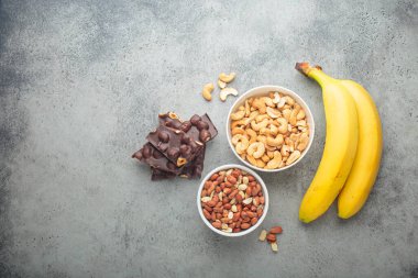 Magnezyum açısından zengin yiyecek çeşitleri: kaju, fıstık, muz ve çikolata fındık, ruh hali ve beyin için sağlıklı bir aperatif