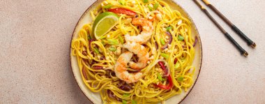 Karidesli, fıstıklı, limonlu ve doğranmış sebzeli Tayland yemeği açık bej arka plan manzaralı çubuklar, Tayland yemeği.