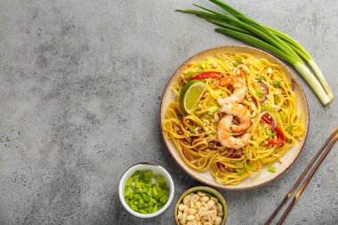 Karides, fıstık, soğan, kireç ve kırmızı dolma biber dilimli Tayland eriştesi seramik tabakta servis edilir. Tayland Tabağı, kopyalama alanı