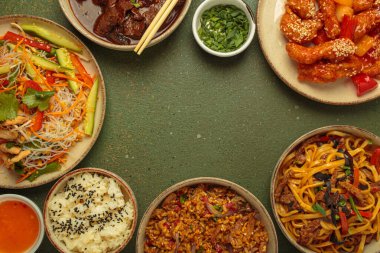 Çeşitli Çin yemekleri, tatlı ve ekşi tavuk, soslu sığır eti, erişte, kızarmış pirinç, salata ve ahşap çubuklar merkezi boş bir alanda çerçeve oluşturuyorlar. Boşluğu kopyala