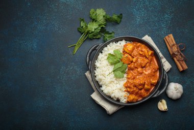 Kremalı domates soslu Hint tavuğu tikka masala. Basmati pilavı, taze kişniş ve baharatla servis ediliyor. Geleneksel Hint yemeği.