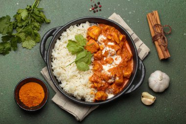 Aromatik Hint tavuğu tikka masala pilav ve kişniş, zerdeçal, sarımsak, tarçın çubukları, geleneksel Hint yemeği.