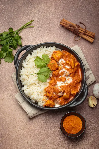 Aromatik Hint tavuğu tikka masala pilav ve kişniş, zerdeçal, sarımsak, tarçın çubukları, geleneksel Hint yemeği.
