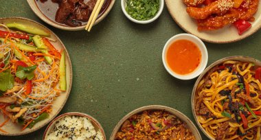 Çeşitli Çin yemekleri, tatlı ve ekşi tavuk, soslu sığır eti, erişte, kızarmış pirinç, salata ve ahşap çubuklar merkezi boş bir alanda çerçeve oluşturuyorlar. Boşluğu kopyala