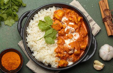 Aromatik Hint tavuğu tikka masala pilav ve kişniş, zerdeçal, sarımsak, tarçın çubukları, geleneksel Hint yemeği.