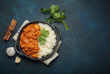 Kremalı domates soslu Hint tavuğu tikka masala. Basmati pilavı, taze kişniş ve baharatla servis ediliyor. Geleneksel Hint yemeği.