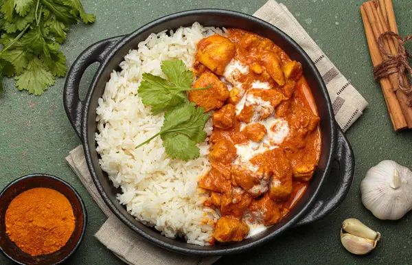 Aromatik Hint tavuğu tikka masala pilav ve kişniş, zerdeçal, sarımsak, tarçın çubukları, geleneksel Hint yemeği.